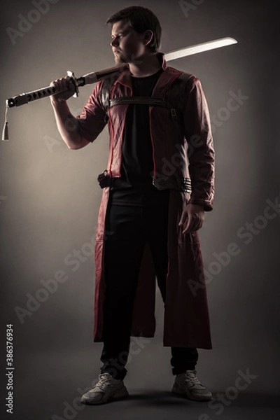 Obraz man with sword in cloak standing in full length