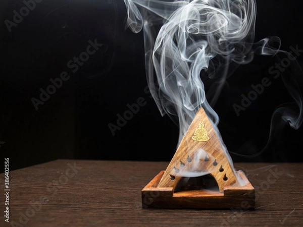 Fototapeta Incense holder full of smoke on dark background