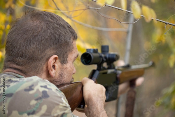 Obraz Close up image of male shooting rifle. Image taken during big game hunting trip. Hunting period, autumn season open.