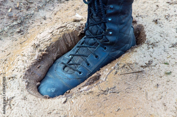 Fototapeta military boot stuck in wet and sticky mud