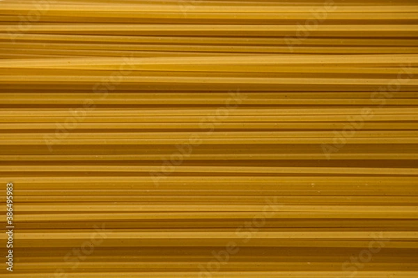 Fototapeta Yellow raw spaghetti background texture close up.