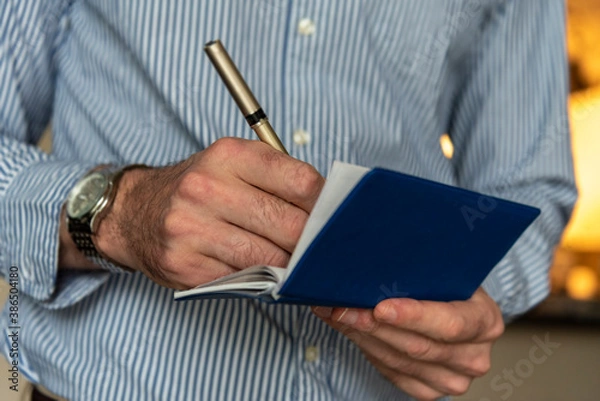 Fototapeta Close up of hands writing a personal check.