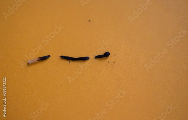 Fototapeta a broken burnt match on orange background