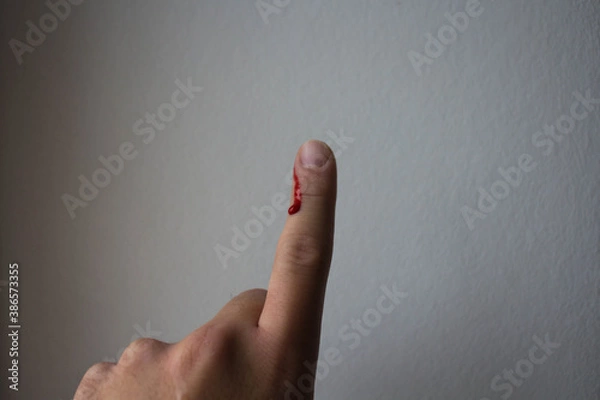 Fototapeta drop of red blood sticks on the finger