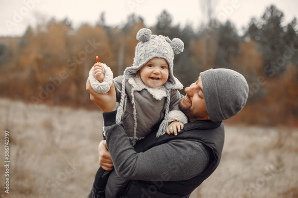 Fototapeta Family in a autumn park. Fathre in a black jacket. Cute little girl