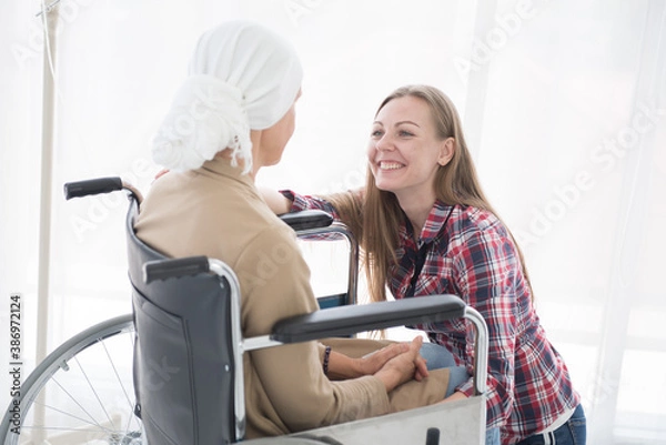 Obraz A beautiful smiling looking girl to encourage breast cancer patients to sit on a wheelchair, cancer concept