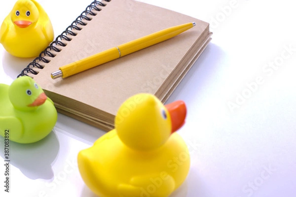 Fototapeta spiral craft notebook, pen for business concept with ducks on white background