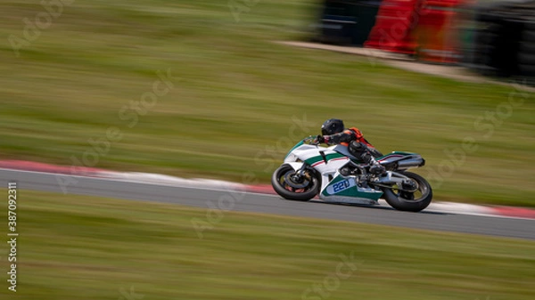 Fototapeta A panning shot of a racing bike cornering on a track.