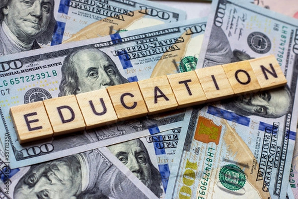 Fototapeta The word education on dollar usa background. College credits, graduation funds, tuition money concept.