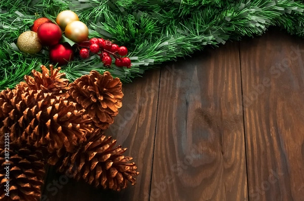 Obraz Christmas or New Year decoration background: pine branches, colorful glass balls on the dark, rustic wooden background and with space for text. Minimalist background. Top View