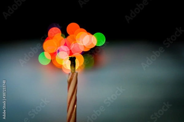 Obraz The candle burns with blurred lights in the background