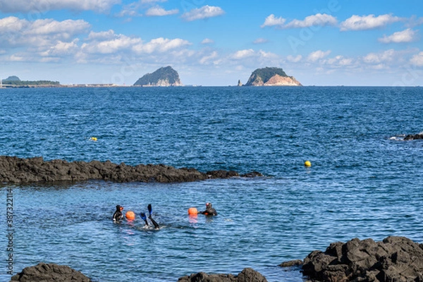 Fototapeta Jeju Island is Korea's leading tourist destination. This is a coastal walkway where you can see two islands. There are haenyeo in the blue sea.