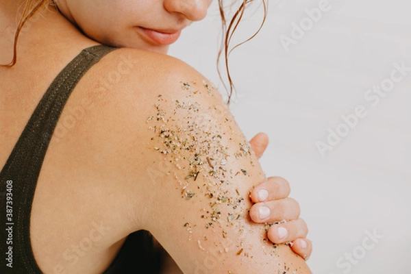 Obraz Woman using body scrub on white background.