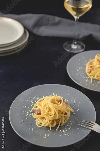 Obraz Traditional Italian dish spaghetti carbonara with bacon in a cream sauce in a plate over dark background. Close-up view with copy space.