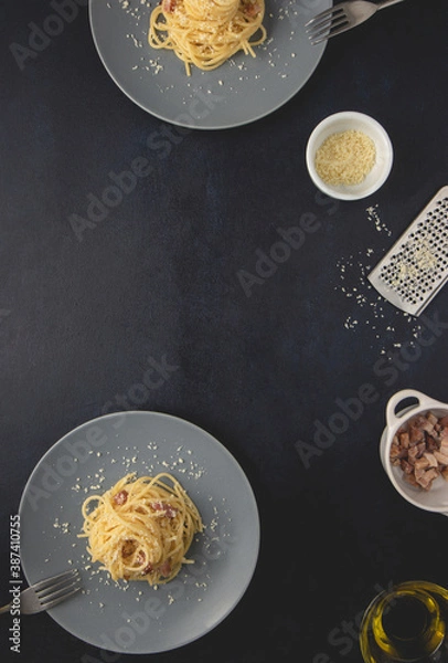 Obraz Traditional Italian dish spaghetti carbonara with bacon in a cream sauce in a plate over dark background. Top view with copy space.
