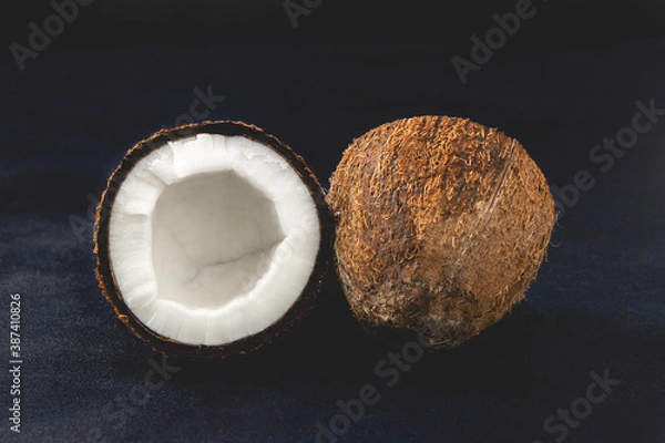 Obraz Fresh coconuts isolated on the dark background. Coconut halves. Close-up view.