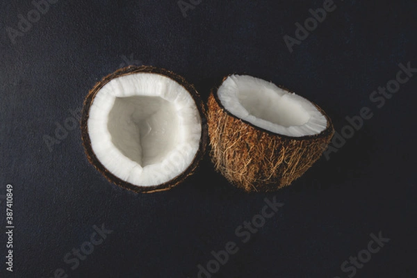 Obraz Fresh coconuts isolated on the dark background. Coconut halves. Top view, flat lay.