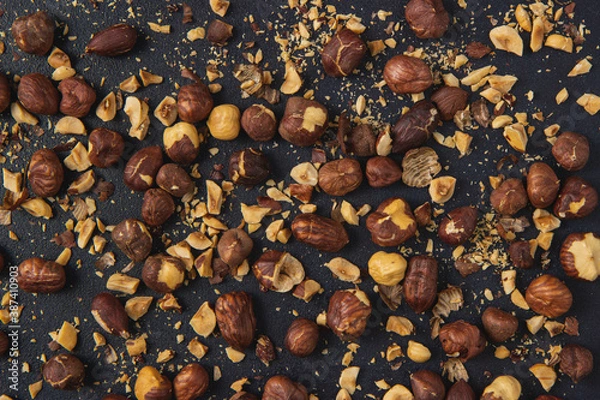 Obraz Background image of roasted hazelnuts isolated on the dark background. Roasted Hazelnuts.