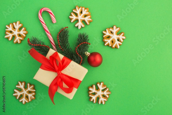 Fototapeta Top view of Christmas gift and gingerbread on the green background