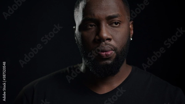 Fototapeta African american man getting an idea indoors. Dreamy man posing in studio