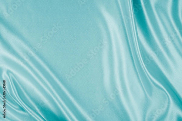 Fototapeta Photography of beautiful wavy turquoise silk satin luxury cloth fabric, abstract background design.