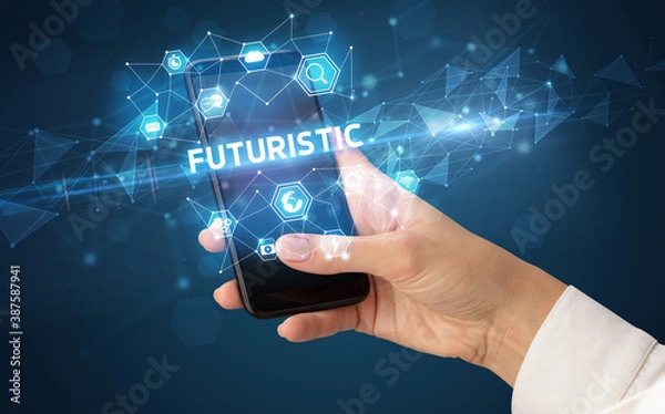 Fototapeta Female hand holding smartphone with FUTURISTIC inscription, modern technology concept