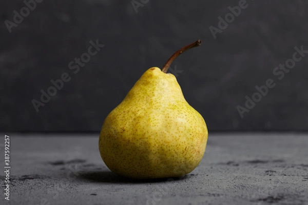 Fototapeta Tasty fresh pear on cocnrete background. 