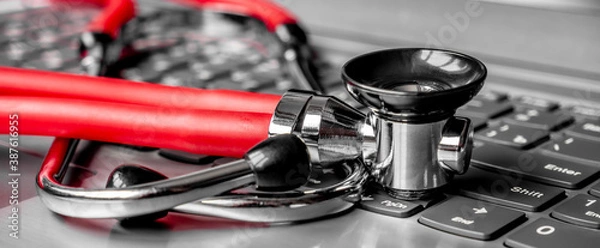 Fototapeta Stethoscope on a computer keyboard. Computer technology is an integral part of medicine, healthcare, and medical health insurance today. Focus on keyboard. Artistic defocus