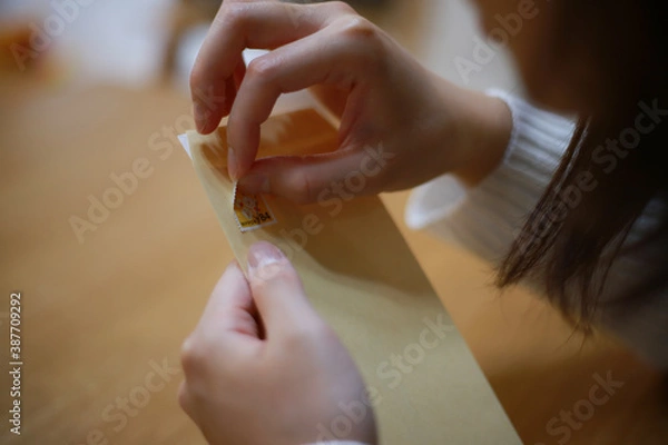 Fototapeta 切手をはがす女性