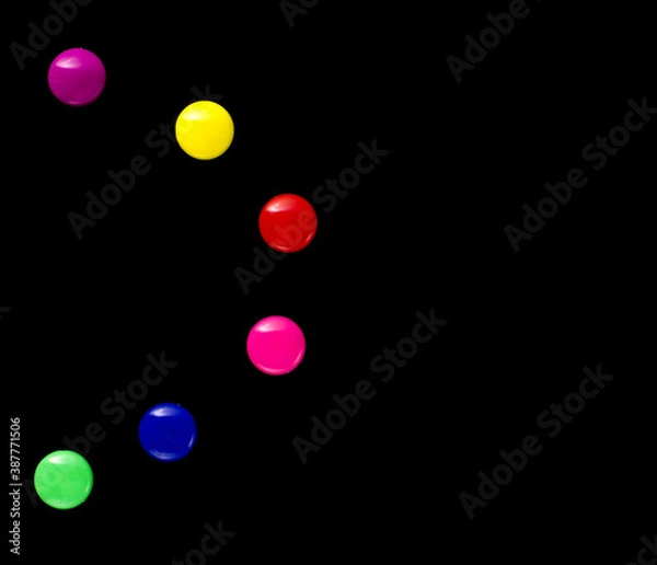 Fototapeta background frame of colored magnetic paper clips in the form of an abstract shape on a black background