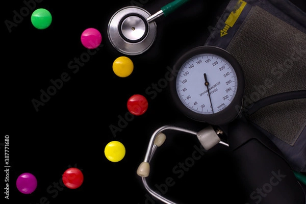 Fototapeta medical tonometer, background frame made of colored magnetic paper clips on black background with space for text