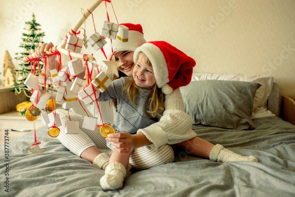 Fototapeta Kids opening Christmas presents.candy and gifts in advent calendar