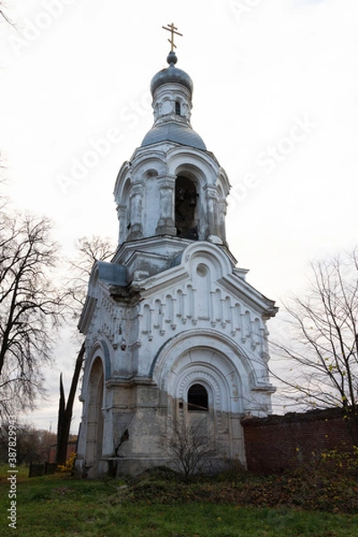 Obraz White and silver church belfry with green grass and cloudy sky in autumn day