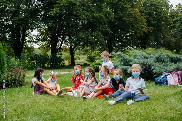 Fototapeta A class of masked school children is engaged in outdoor training during the epidemic. Back to school, learning during the pandemic
