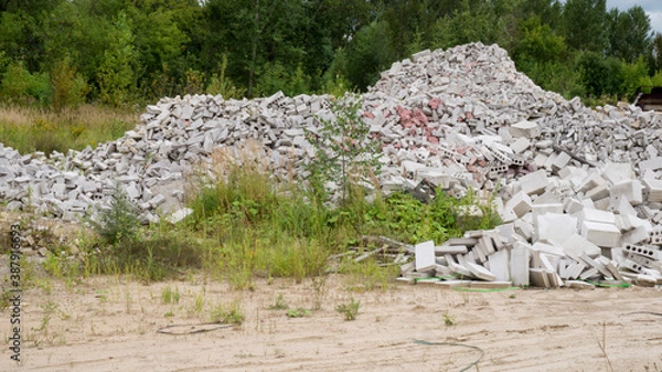 Fototapeta Pile of ruined building bricks and blocks in outdoor nature