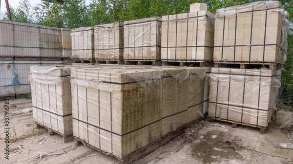 Fototapeta Packed with bandage tapes and stretch film bricks are stacked on wooden pallets in an abandoned warehouse