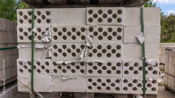 Fototapeta Packed with bandage tapes and stretch film stack of bricks are stacked on wooden pallets in an abandoned warehouse