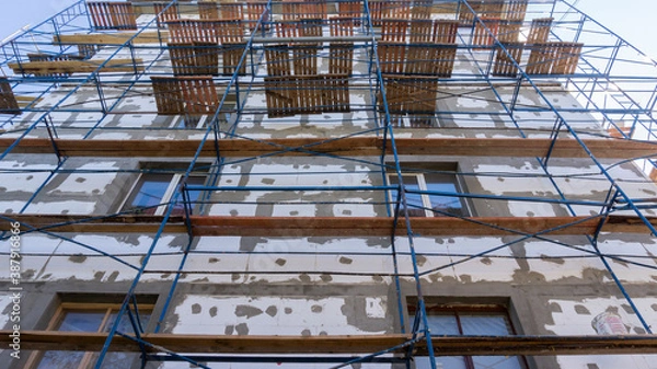Fototapeta Scaffolding on a foam-insulated building walls