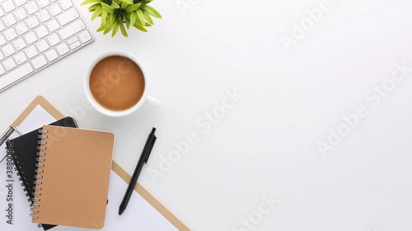 Fototapeta Top view white wooden workspace office desk with computer and office supplies. Flat lay work table with blank notebook, keyboard, green leaf and coffee cup. Copy space for your advertising content.