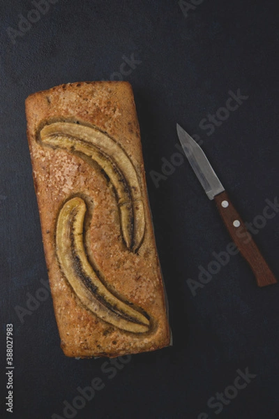 Obraz Homemade banana nut bread loaf isolated on the dark background. Table top view and copy space.