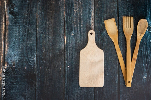 Fototapeta Przybory kuchenne na ciemnych deskach.