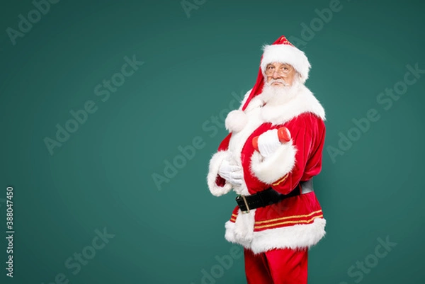Fototapeta Santa Claus exercising with dumbbells.