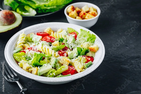 Fototapeta Caesar Pasta Salad with avocado, croutons and tomatoes