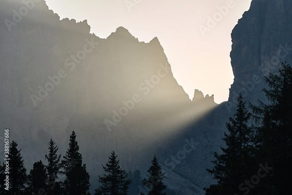 Fototapeta Sunlight beam shining through rock formations on a misty morning