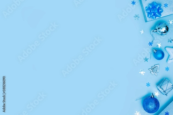 Fototapeta Blue Christmas or New Year background. Blue and silver xmas decoration with copy space. Top view Side border made with blue and silver balls, gifts, stars and snowflakes. 