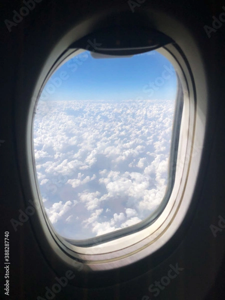Fototapeta Puffy clouds outside the window