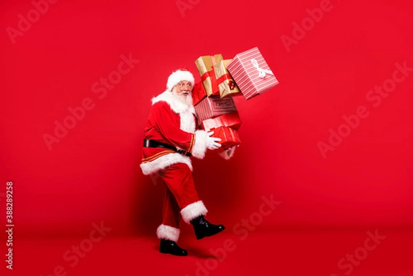 Fototapeta Santa Claus with a lot of gifts on a red background.