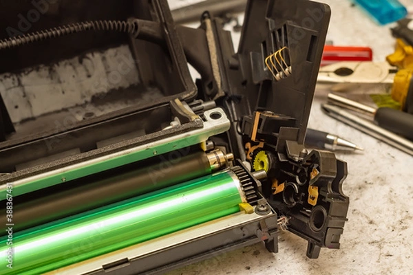 Fototapeta a worn out disassembled laser printer cartridge is lying on the service center table next to the tools