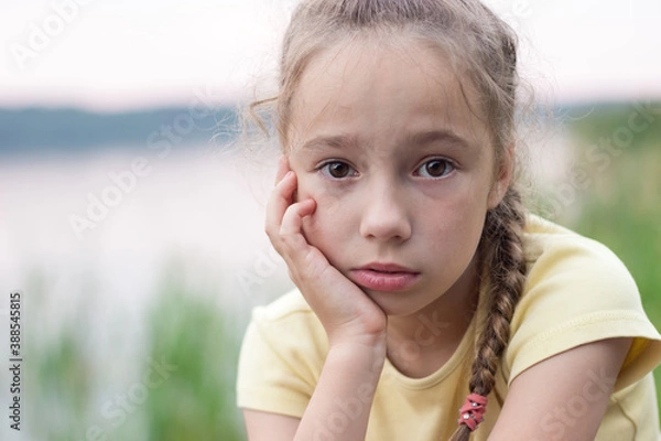Obraz Sad little girl is crying and  looking with serious face at camera