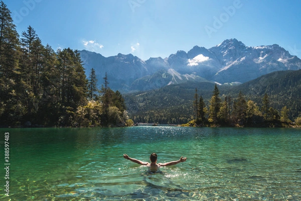 Fototapeta Man swimming in a beautiful mountain lake in the middle of the nature in the Bavarian Alps, Germany. Famous destination in Europe